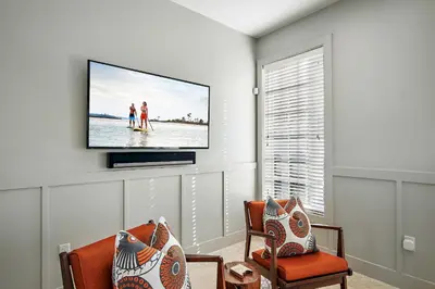 a living room with a flat screen tv on a wall at 34 S Briland Lane Carriage House in Rosemary Beach