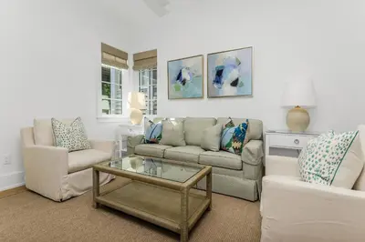 a living room with two couches and a coffee table at Harp's Haven Carriage House in Rosemary Beach