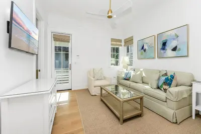 a living room with a couch and a tv at Harp's Haven Carriage House in Rosemary Beach