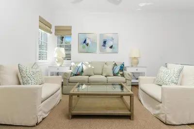 a living room with two couches and a coffee table at Harp's Haven Carriage House in Rosemary Beach