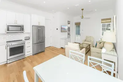 a kitchen and living room with a table and chairs at Harp's Haven Carriage House in Rosemary Beach