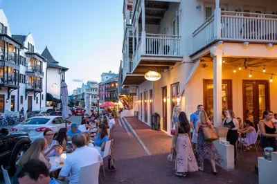 a group of people sitting at tables on a city street at Harp's Haven Carriage House in Rosemary Beach