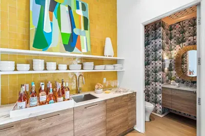 a kitchen with a sink and a counter with bottles at 30A Showhouse in Rosemary Beach