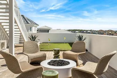a patio with chairs and a table and a golf course at 30A Showhouse in Rosemary Beach