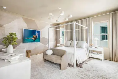 a bedroom with a bed and a chair in a room at 30A Showhouse in Rosemary Beach