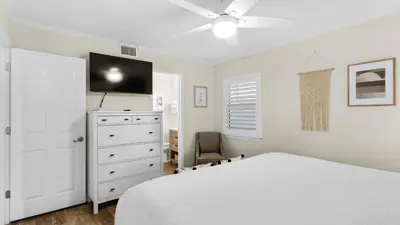 a bedroom with a bed and a dresser with a tv at Eastern Shores 103 in Santa Rosa Beach