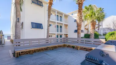 a wooden bench on a deck in front of a building at Eastern Shores 103 in Santa Rosa Beach