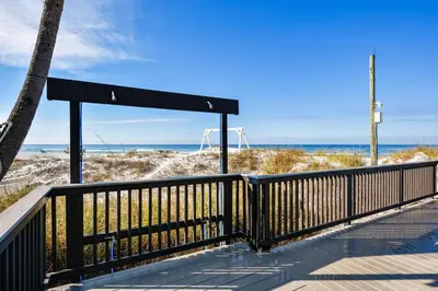 a boardwalk to the beach with the ocean in the background at Sunbird 102E By Book That Condo in Panama City Beach