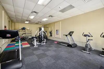 a gym with treadmills and elliptical machines at Sunbird 102E By Book That Condo in Panama City Beach
