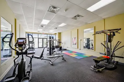 a gym with bikes and tread machines in a room at Sunbird 102E By Book That Condo in Panama City Beach