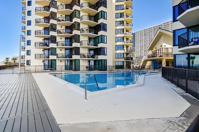 a swimming pool in front of a apartment building at Sunbird 102E By Book That Condo in Panama City Beach