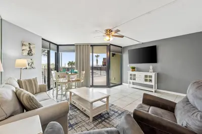 a living room with two couches and a tv at Sunbird 102E By Book That Condo in Panama City Beach