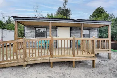 a cabin with a large wooden deck at Lakefront Panama City Studio with Hot Tub Access in Panama City
