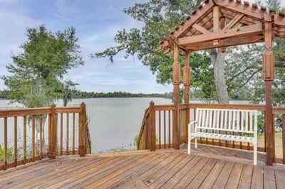 a wooden gazebo with a bench sitting on a deck at Lakefront Panama City Studio with Hot Tub Access in Panama City