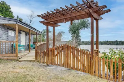 a wooden deck with a pergola next to a house at Lakefront Panama City Studio with Hot Tub Access in Panama City