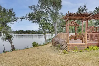 a wooden gazebo on the side of a lake at Lakefront Panama City Studio with Hot Tub Access in Panama City