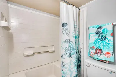 a bathroom with a tub and a shower curtain at Lakefront Panama City Studio with Hot Tub Access in Panama City