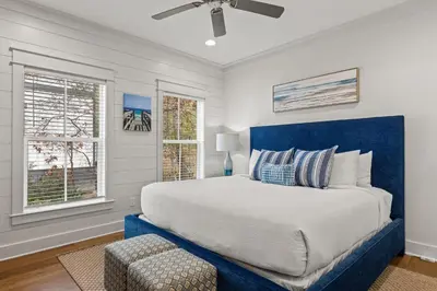a bedroom with a large bed and a blue headboard at 30A Magnolia Cottages by the Sea by Panhandle Getaways in Seacrest