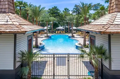 an image of a pool at a resort with palm trees at 30A Magnolia Cottages by the Sea by Panhandle Getaways in Seacrest