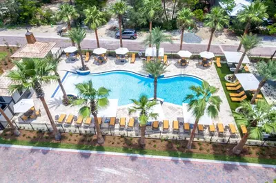 an overhead view of a pool with chairs and palm trees at 30A Magnolia Cottages by the Sea by Panhandle Getaways in Seacrest