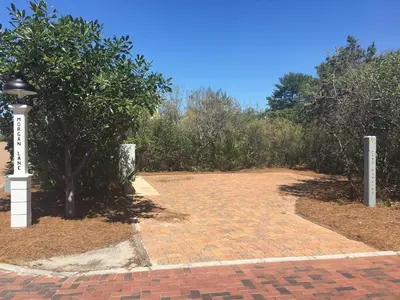 a brick driveway with a light pole and trees at 30A Magnolia Cottages by the Sea by Panhandle Getaways in Seacrest