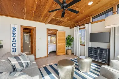 a living room with a ceiling fan and a television at Dry Dock in Seagrove Beach