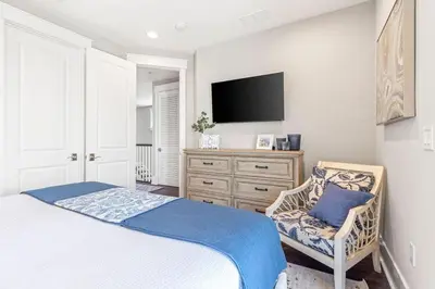 a bedroom with a bed and a tv and a chair at Nature and the Beach in Santa Rosa Beach
