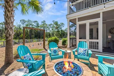 a patio with blue chairs and a fire pit at Nature and the Beach in Santa Rosa Beach