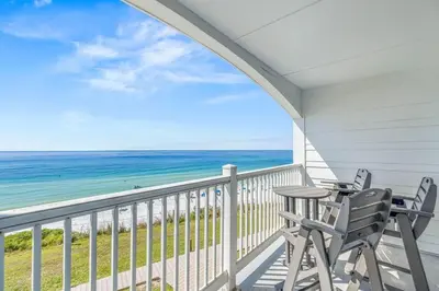 a porch with two chairs and a table and the ocean at Blue Tide 6B in Inlet Beach