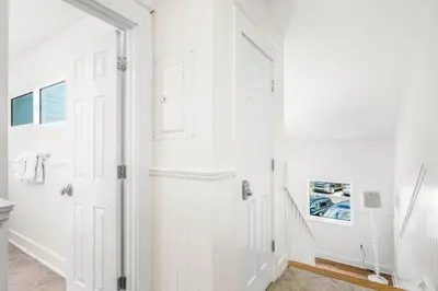 a bathroom with white walls and a white door at Blue Tide 6B in Inlet Beach