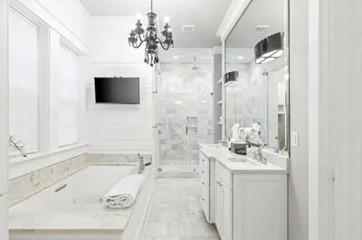 a white bathroom with a tub and a tv at A Shore Bet in Santa Rosa Beach