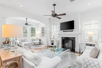 a living room with white furniture and a fireplace at A Shore Bet in Santa Rosa Beach