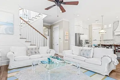 a living room with white furniture and a ceiling fan at A Shore Bet in Santa Rosa Beach
