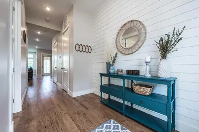 a hallway with a blue console table and a mirror at Mai Tide in Inlet Beach