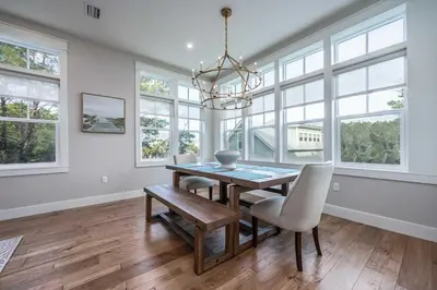 a dining room with a table and chairs and windows at Mai Tide in Inlet Beach