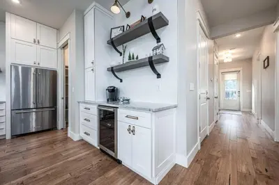 a kitchen with white cabinets and a hardwood floor at Mai Tide in Inlet Beach
