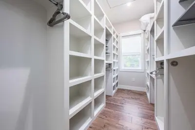 a walk in closet with white shelves and a window at Mai Tide in Inlet Beach