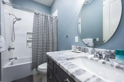 a bathroom with a sink and a toilet and a mirror at Mai Tide in Inlet Beach