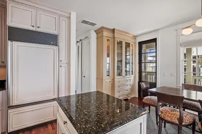 a kitchen with white cabinets and a black counter top at 34 South Briland Main House in Rosemary Beach