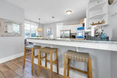 a kitchen with a large counter and stools at Seagrove Bungalow 110 - One Ten Again in Santa Rosa Beach