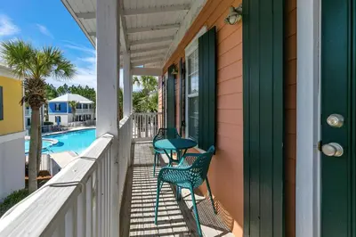 a porch with two chairs and a swimming pool at Seagrove Bungalow 110 - One Ten Again in Santa Rosa Beach