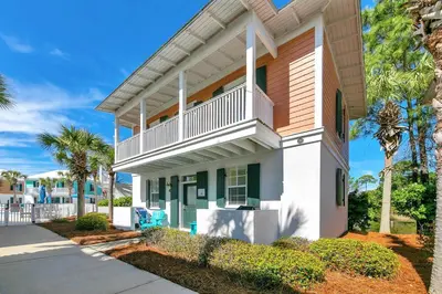 a house with a balcony and palm trees at Seagrove Bungalow 110 - One Ten Again in Santa Rosa Beach