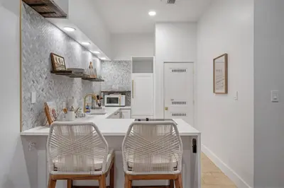 a white kitchen with two chairs and a counter at 30A Villages of South Walton B190 - Free Bicycles in Seacrest