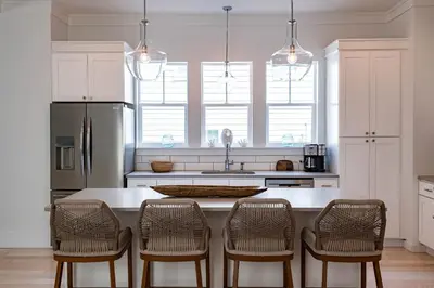 a kitchen with a counter with chairs and a refrigerator at Ocho Cinco in Santa Rosa Beach
