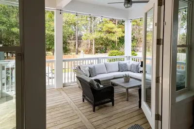 a screened in porch with a couch and a table at Ocho Cinco in Santa Rosa Beach