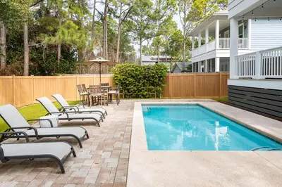 a swimming pool with lounge chairs and a table at Ocho Cinco in Santa Rosa Beach
