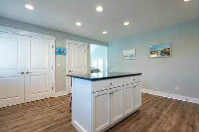 a kitchen with white cabinets and a black counter top at 50 Sea Turtle in Santa Rosa Beach