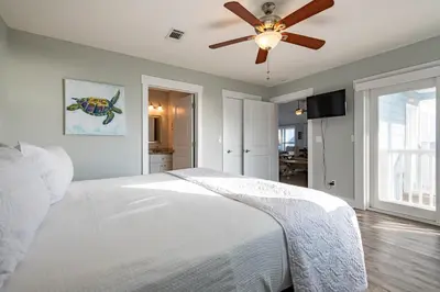 a bedroom with a white bed and a ceiling fan at 50 Sea Turtle in Santa Rosa Beach