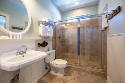 a bathroom with a shower and a toilet and a sink at Follow the Heron in Santa Rosa Beach