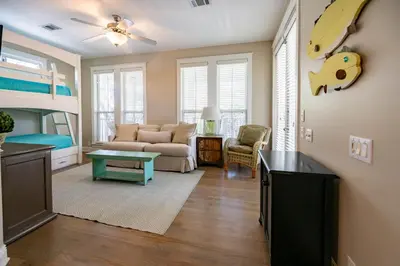 a living room with a couch and a bunk bed at Follow the Heron in Santa Rosa Beach
